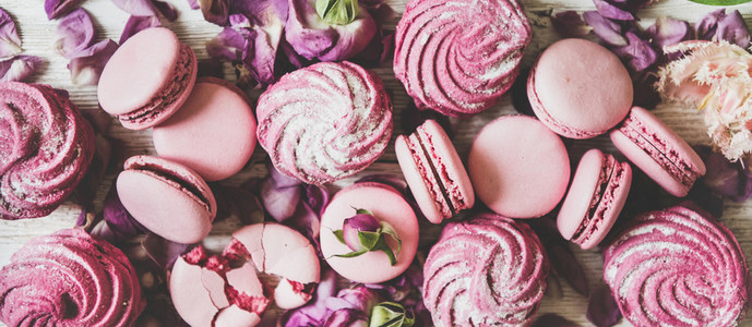 Sweet pink macarons  marshmallows and spring flowers and petals  close up