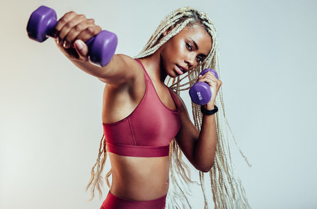 Close up of african american fitness woman using dumbbells