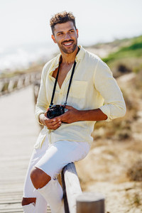 Smiling man photographing in a coastal area
