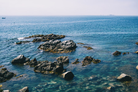 Seascape with views of the horizon with some steep rocks and crystalline blue waters