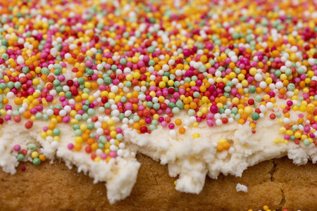Close up multicolor sprinkles on cake frosting