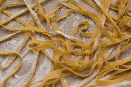 Close up fresh homemade pasta on floured parchment paper