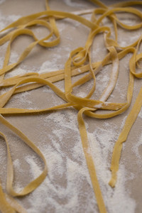Fresh homemade pasta on floured parchment paper
