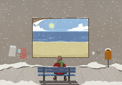 Man sitting on snowy bench looking at beach billboard