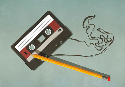 Pencil unwinding cassette tape on green background