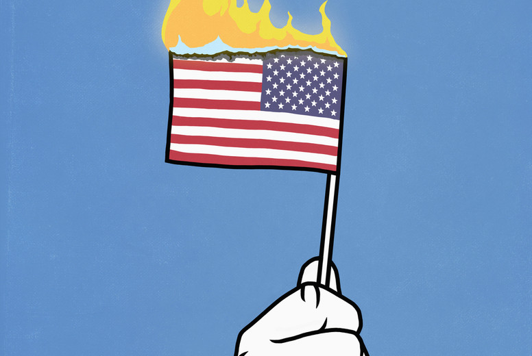 Hand holding burning American flag on blue background