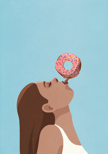 Playful young woman balancing donut on tongue