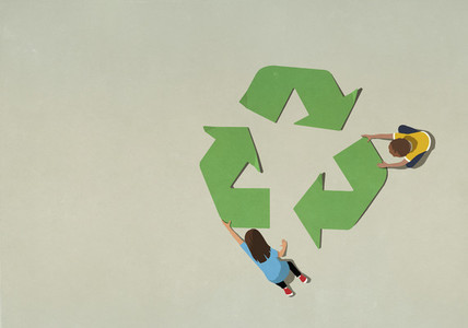 Boy and girl assembling green recycling symbol