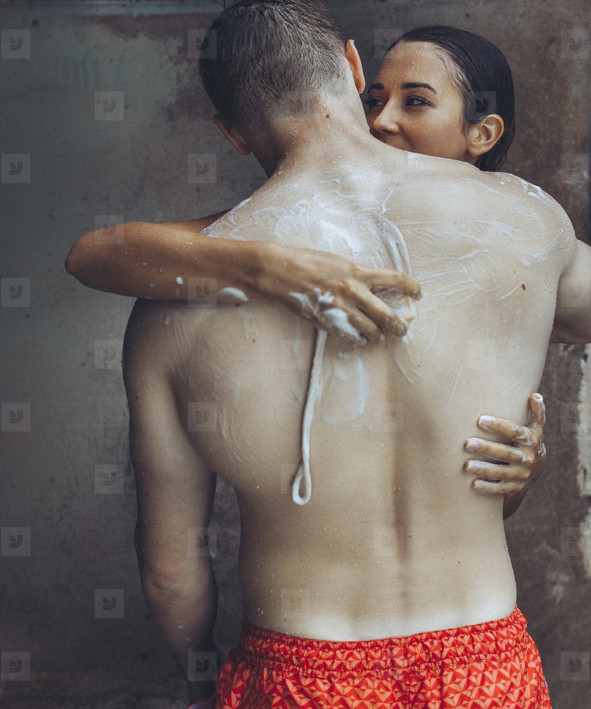 Sensual young couple with soap in outdoor shower