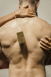 Sensual couple with soap on a rope showering together