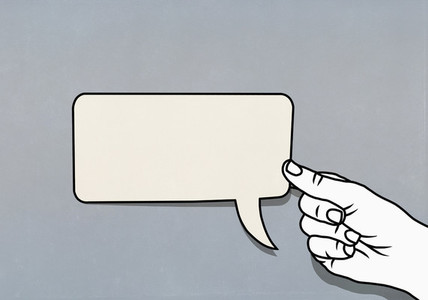 Hand holding speech bubble adhesive note