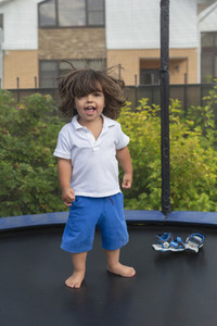 Portrait happy with cute toddler boy on backyard trampoline