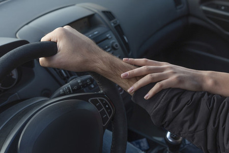 Woman touching arm of boyfriend driving car
