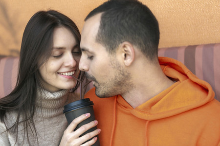 Romantic young couple sharing coffee with straws