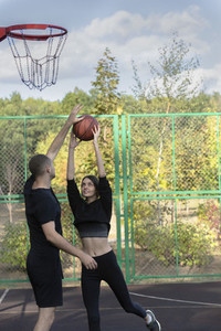 Young couple playing basketball at park basketball court