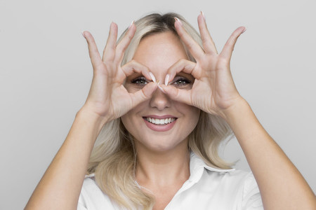 Portrait playful woman gesturing finger goggles