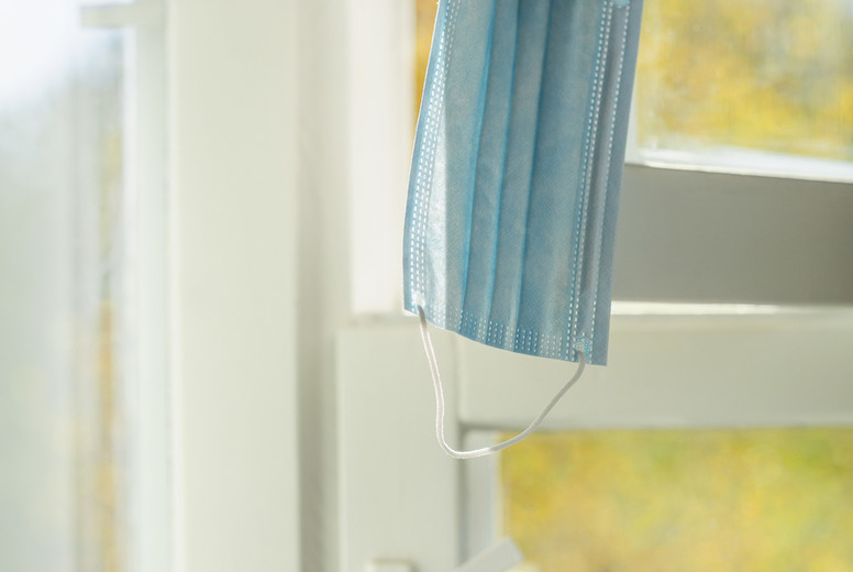 Face mask hanging from window latch