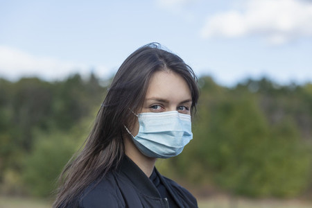 Portrait confident young brunette woman in face mask