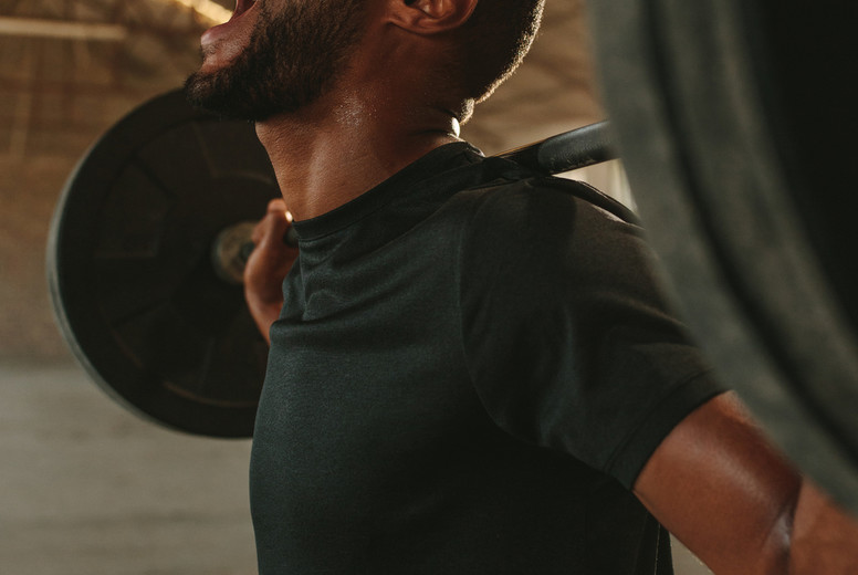 Strong man doing intense barbell workout