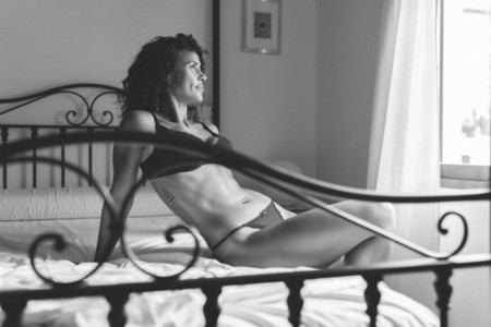 Middle aged woman In lingerie posing on the bed