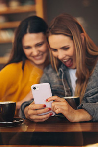 Friends looking funny updates on mobile phone