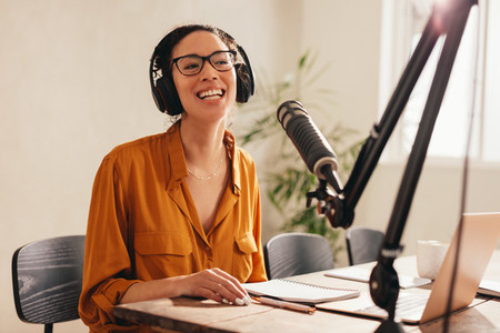 Smiling podcast host working form home