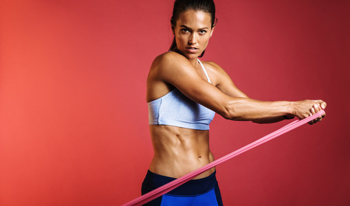 Muscular woman using resistance bands for training