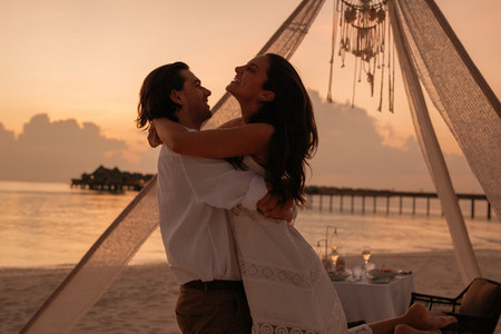 Romantic couple hugging at a beach restaurant