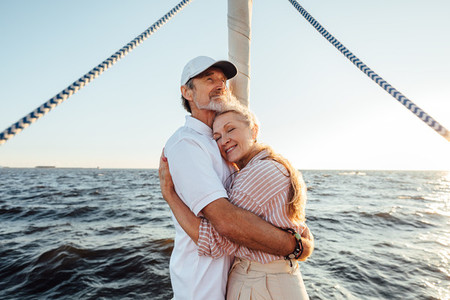 Romantic elderly couple enjoying a sunset on a private yacht