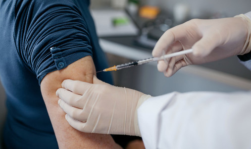 Arm of unrecognizable adult receiving coronavirus vaccine