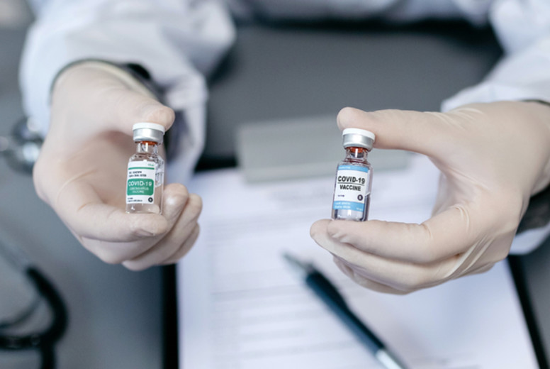 Doctor showing her patient two different coronavirus vaccine opt