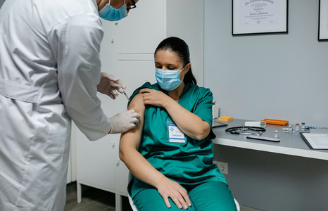 Female surgeon receiving coronavirus vaccine