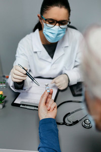 Doctor explaining to her patient the benefits and risks of the coronavirus vaccine