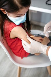 Girl receiving coronavirus vaccine at doctors office
