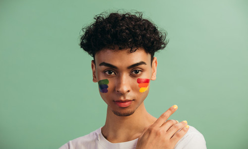 Man with LGBT flag painted on his cheeks