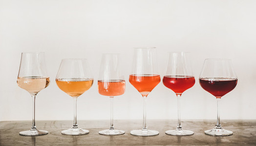 Shades of Rose wine in glasses on concrete table
