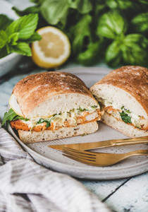 Breakfast with fish sandwich filled with lemon and greens
