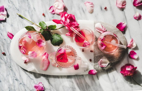 Rose lemonade with ice cubes and fresh rose petals