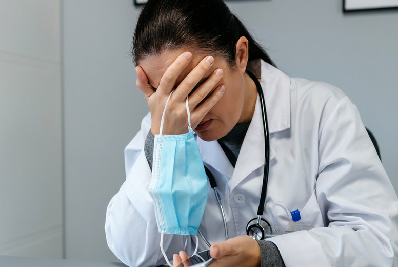 Worried female doctor with hands on face