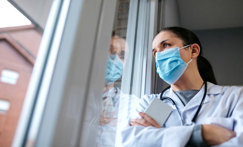 Female doctor looking out the hospital window