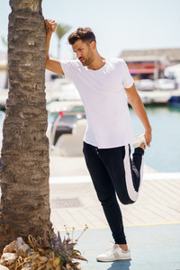 Man stretching after exercise in a harbour