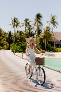 Woman riding bicycle at a tropical beach resort
