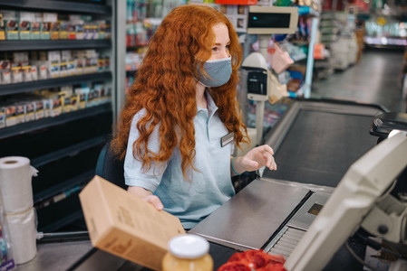 Supermarket cashier with face mask