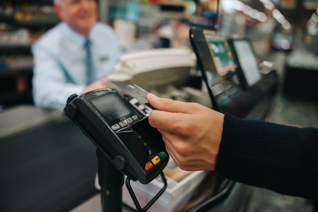 Customer making contactless payment at supermarket