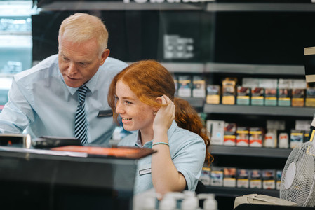 Manager giving training to a new employee at supermarket