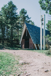 a church with nothing around in the middle of a hiking trail  surrounded by trees and bushes