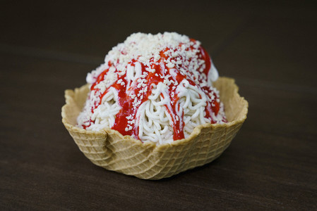 Close up Spaghettieis ice cream sundae with strawberry sauce in waffle cone cup