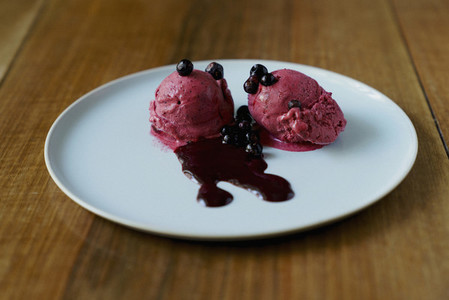 Raspberry sorbet with blueberry sauce on plate