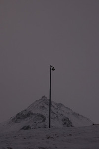 Street lamp against snowy mountain