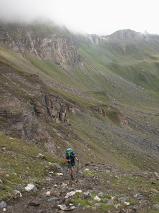 Woman trekking up rugged mountain